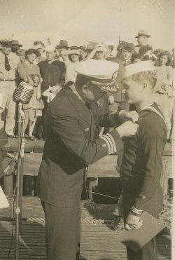 Capt O'Niel pinning medal on Billy Stamper